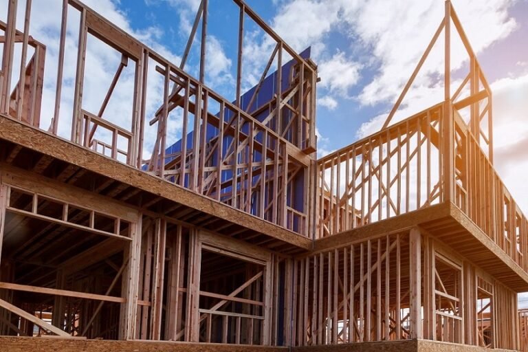 New house under construction framing against a blue sky